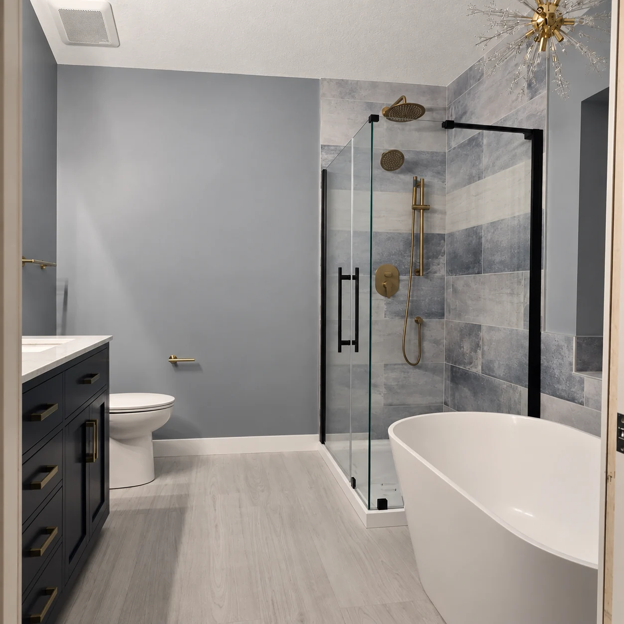 Bathroom with a glass shower, freestanding white tub, dark vanity, and light floor tile